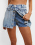 Denim shorts being worn on a plain background