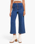A model wearing a pair of high-waisted, wide-leg blue denim jeans with a button fly and front patch pockets, paired with white heeled ankle boots against a light gray studio background.