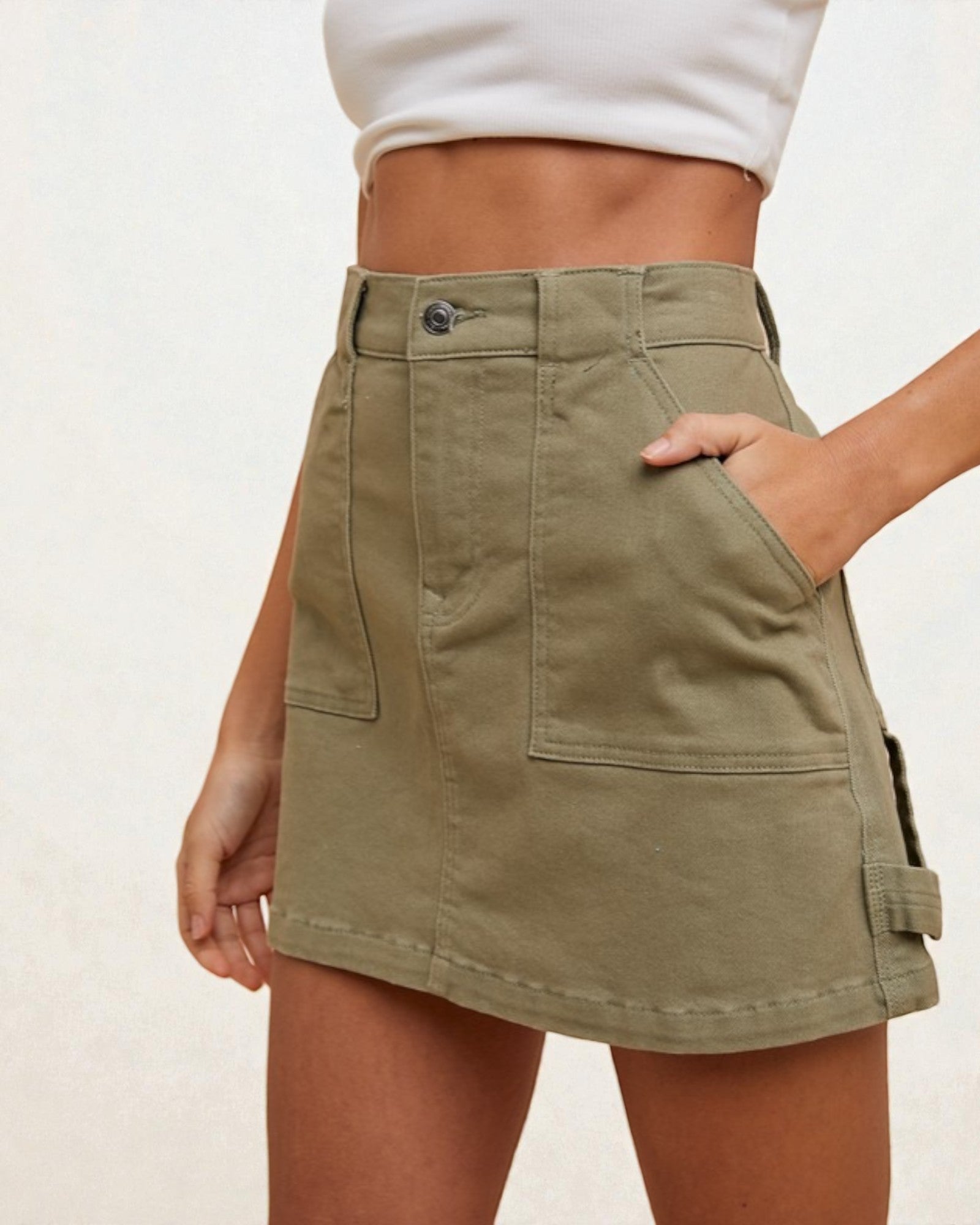 Person wearing a green skirt with a plain background