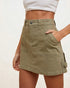 Person wearing a green skirt with a plain background