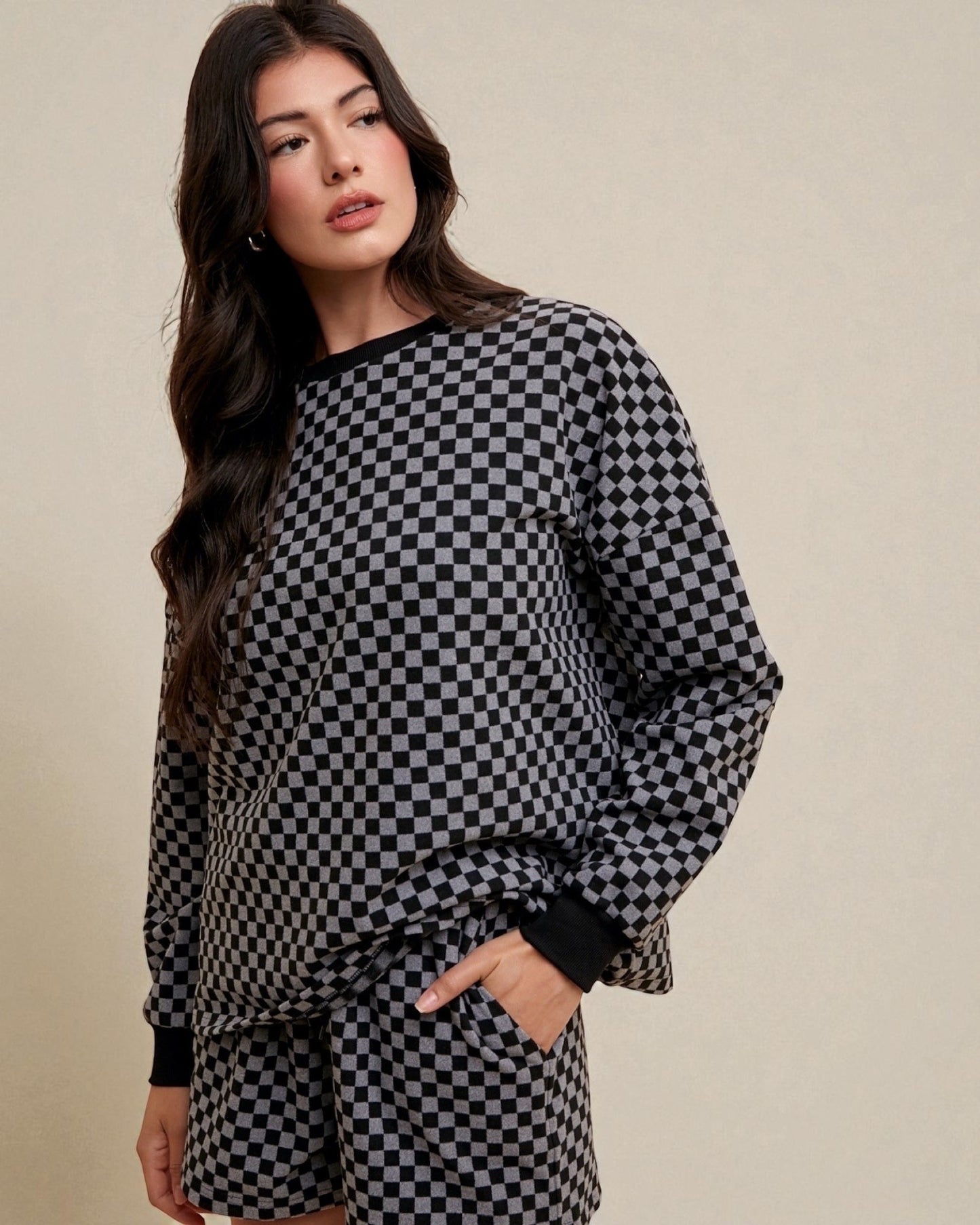 Woman wearing a black and white checkered outfit on a beige background