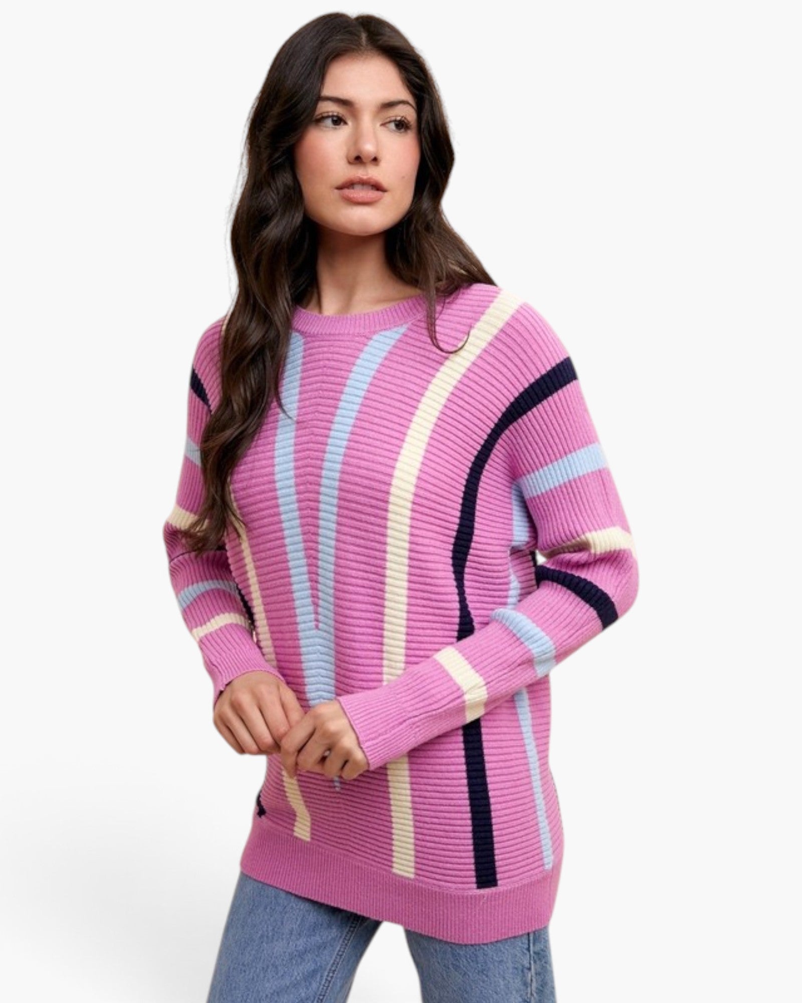 A woman wearing a pink ribbed knit sweater with vertical stripes in light blue, cream, and black, paired with blue jeans, against a plain white background.