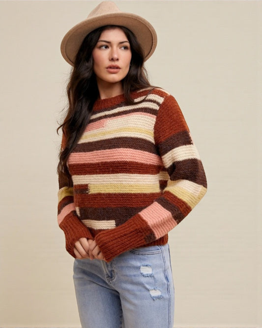 Woman wearing a striped sweater and hat against a plain background