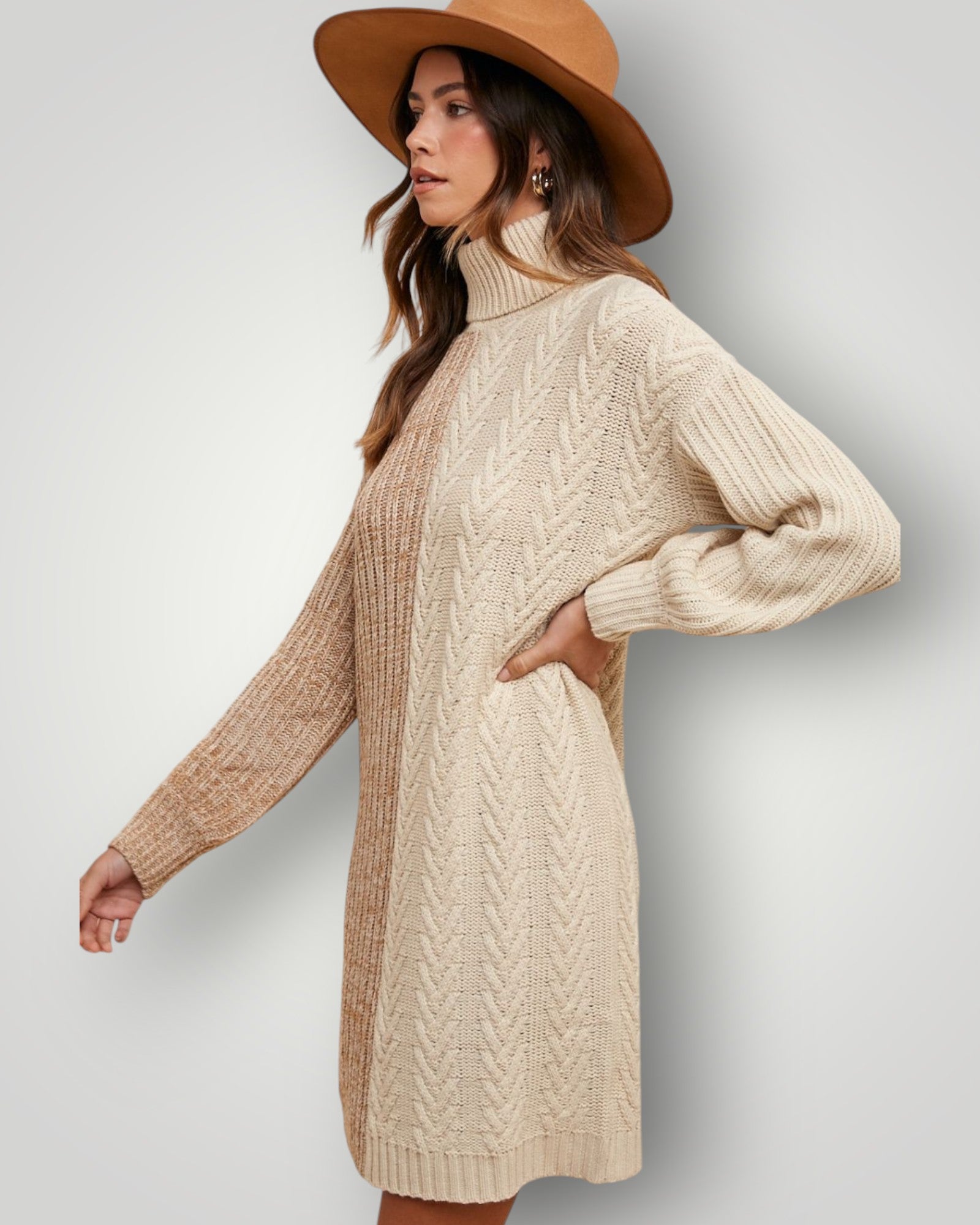 Woman wearing a beige cable knit sweater dress and brown hat on a light gray background