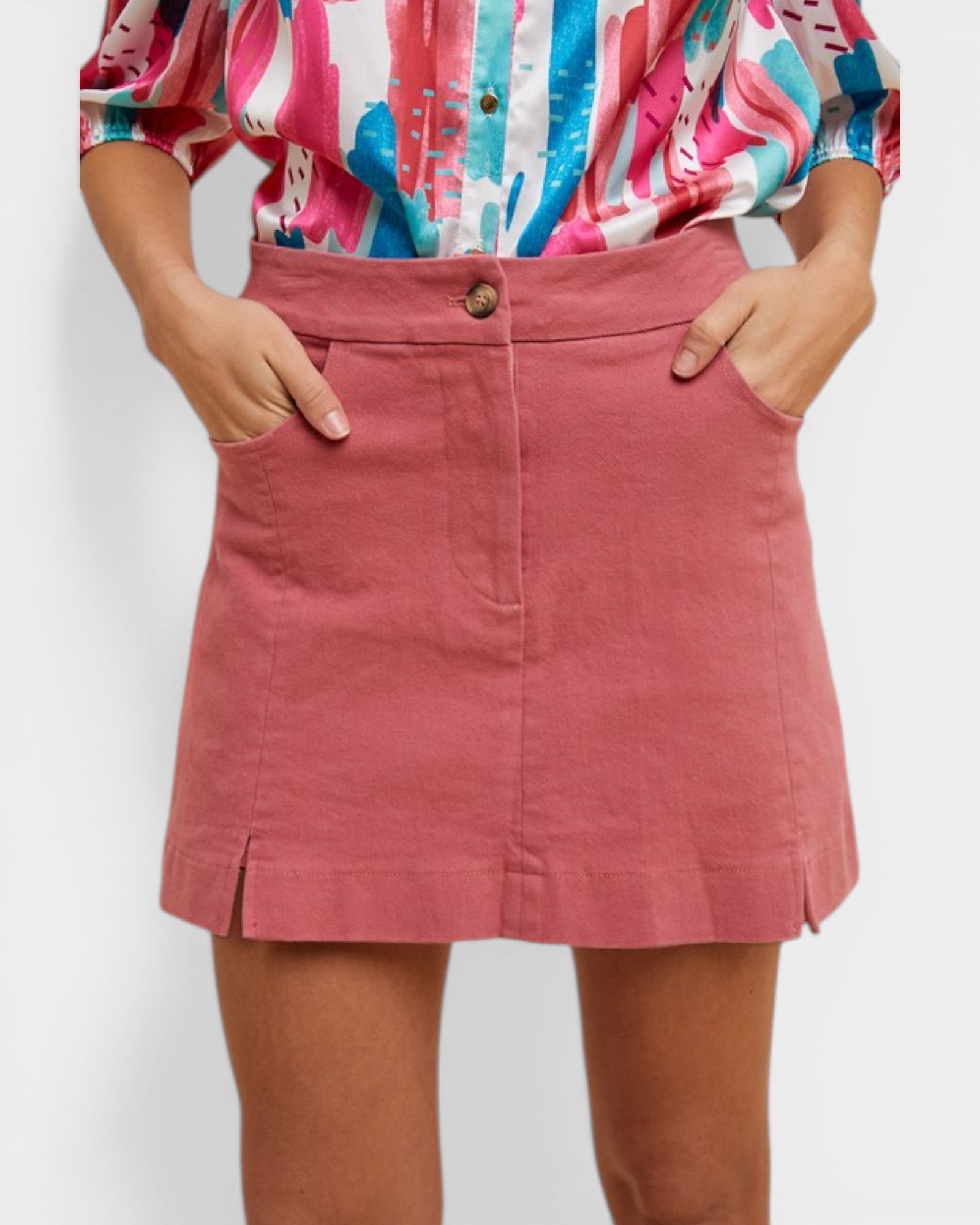 Person wearing a colorful shirt and pink skirt on a white background