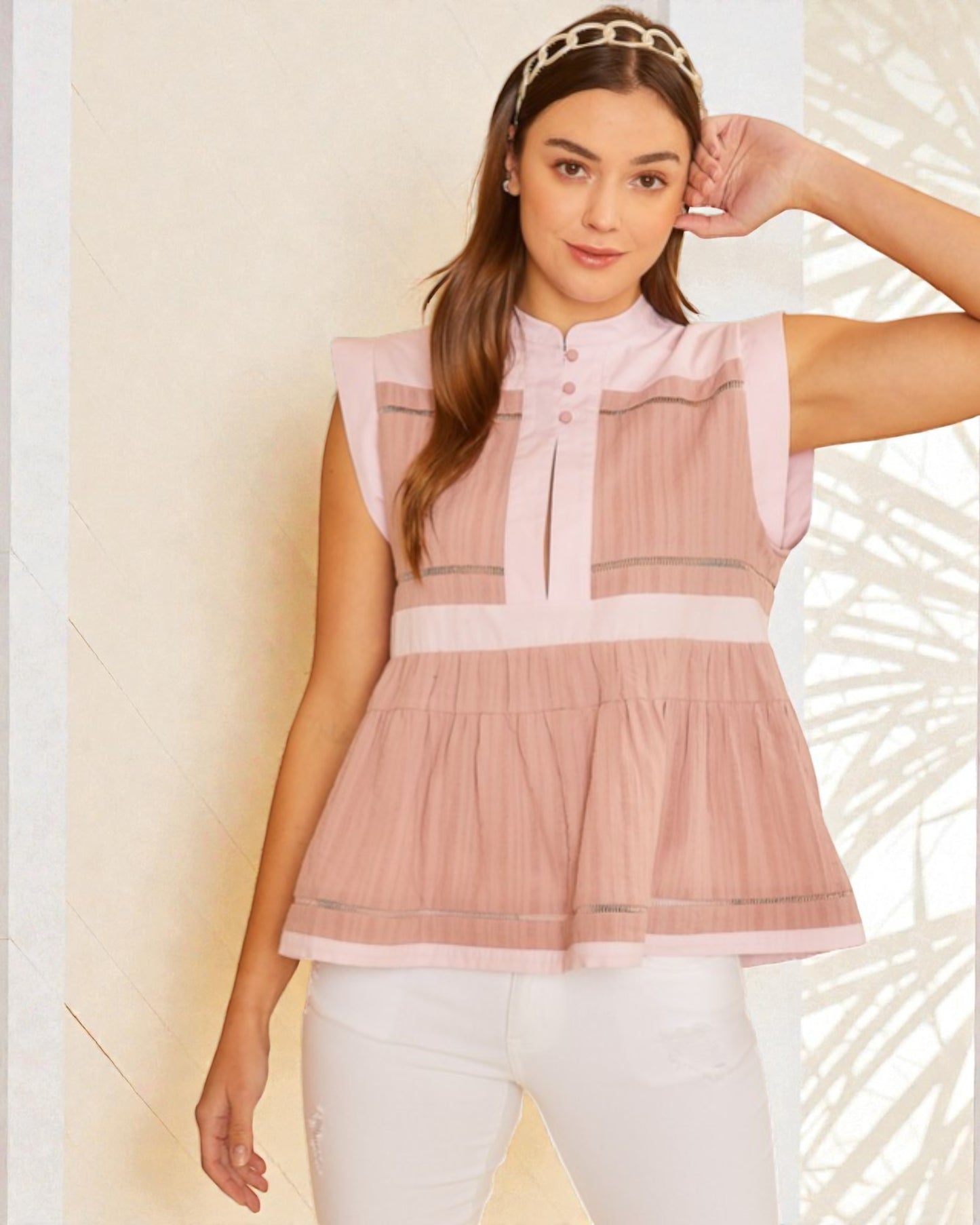 Woman wearing a pink sleeveless top with a white background