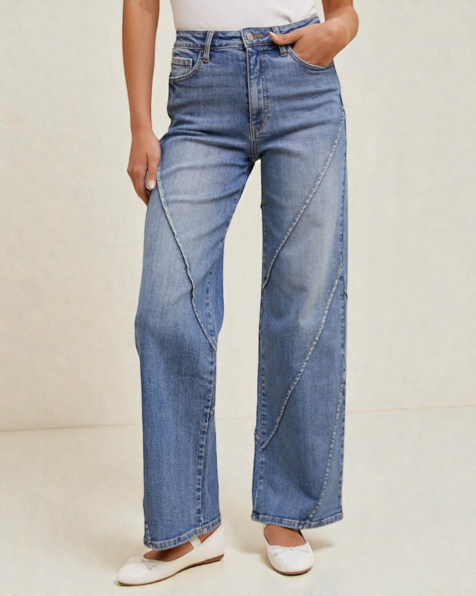 Person wearing blue wide-leg jeans on a plain background