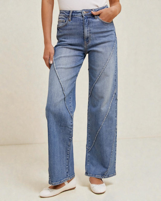 Person wearing blue wide-leg jeans on a plain background