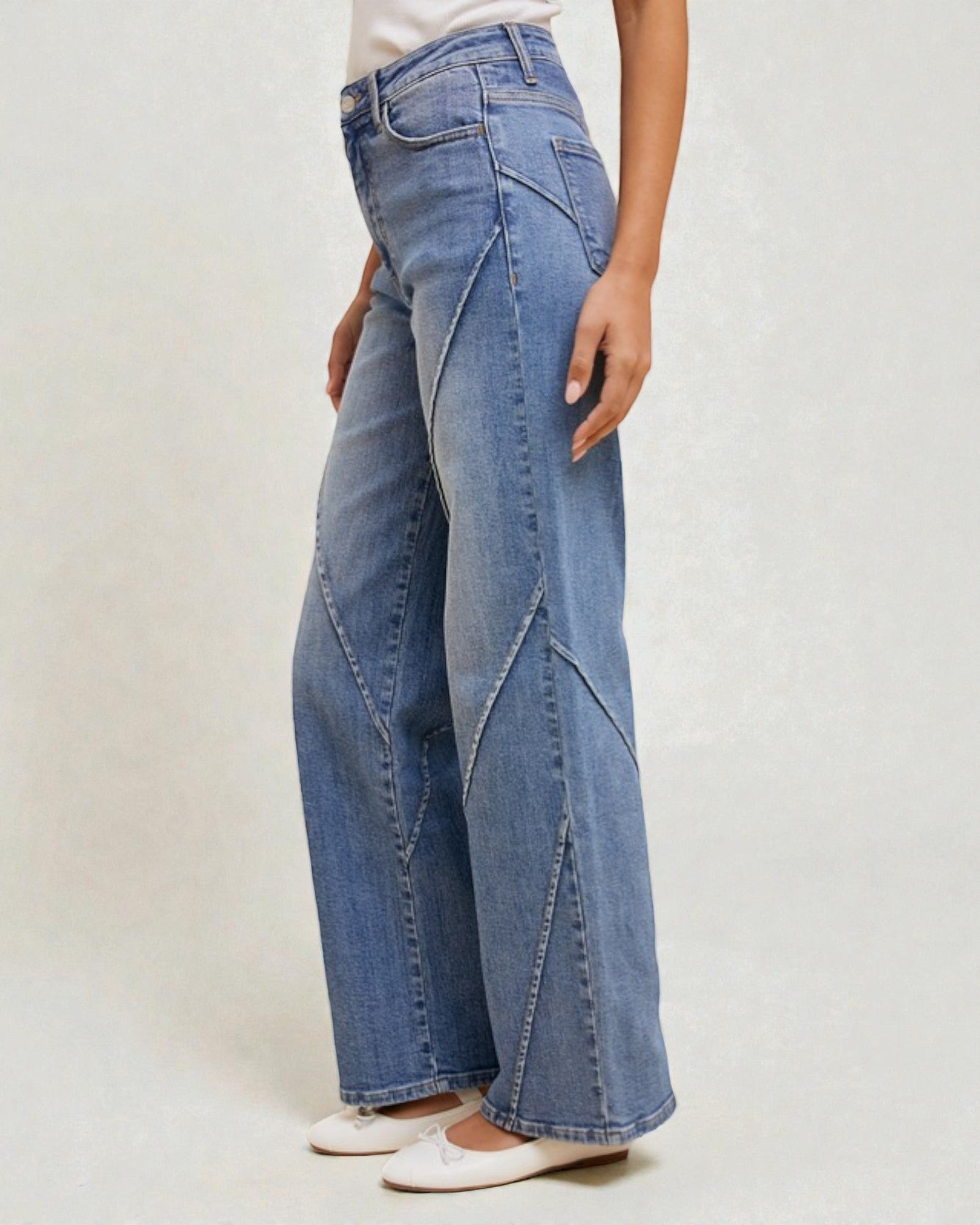 Person wearing blue wide-leg jeans on a plain background