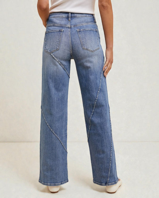 Person wearing blue wide-leg jeans on a plain background