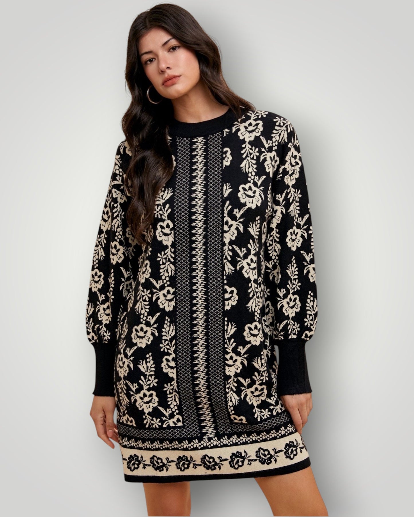 Woman wearing a black and white patterned dress against a plain background