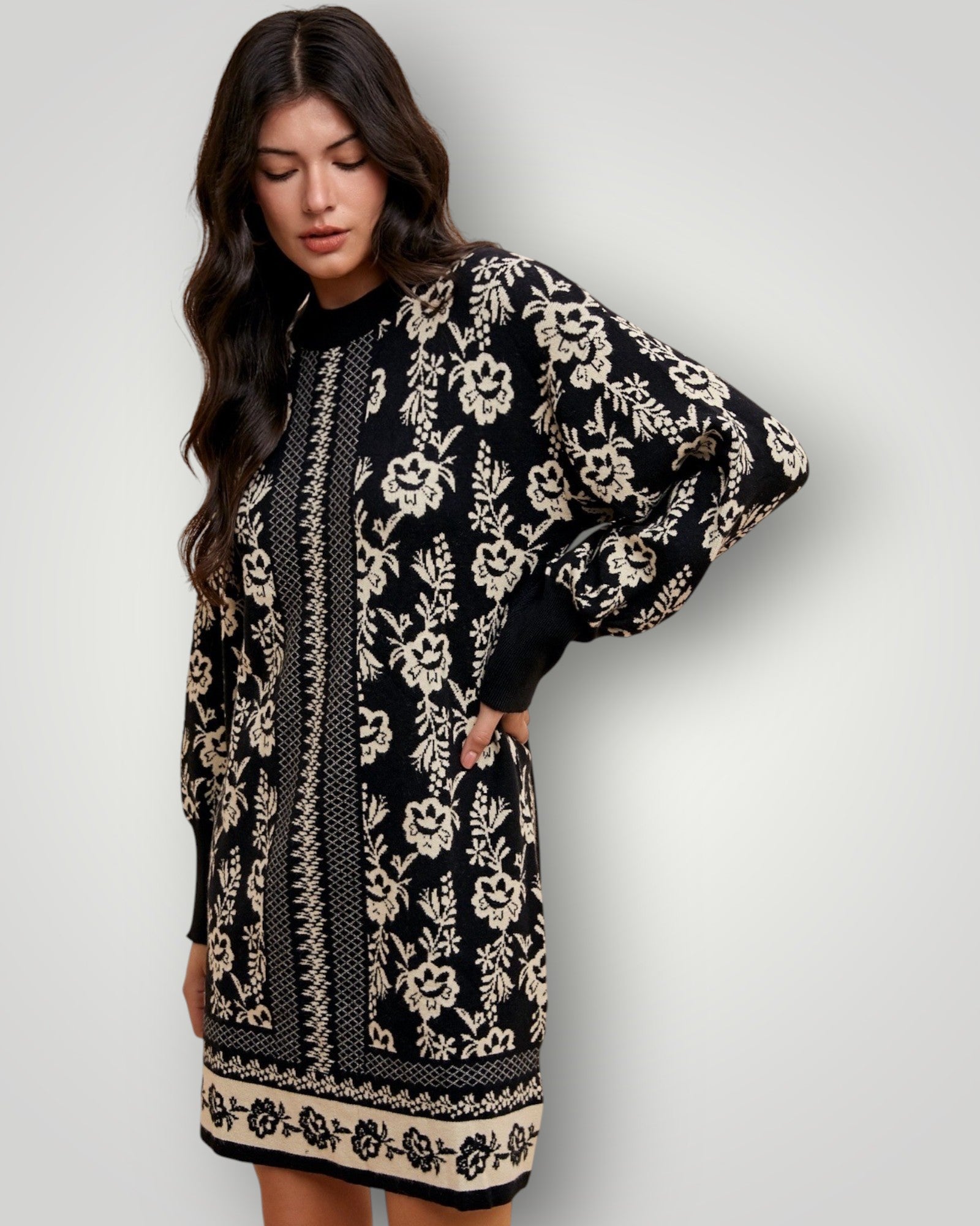 Woman wearing a black and white floral patterned dress against a plain background