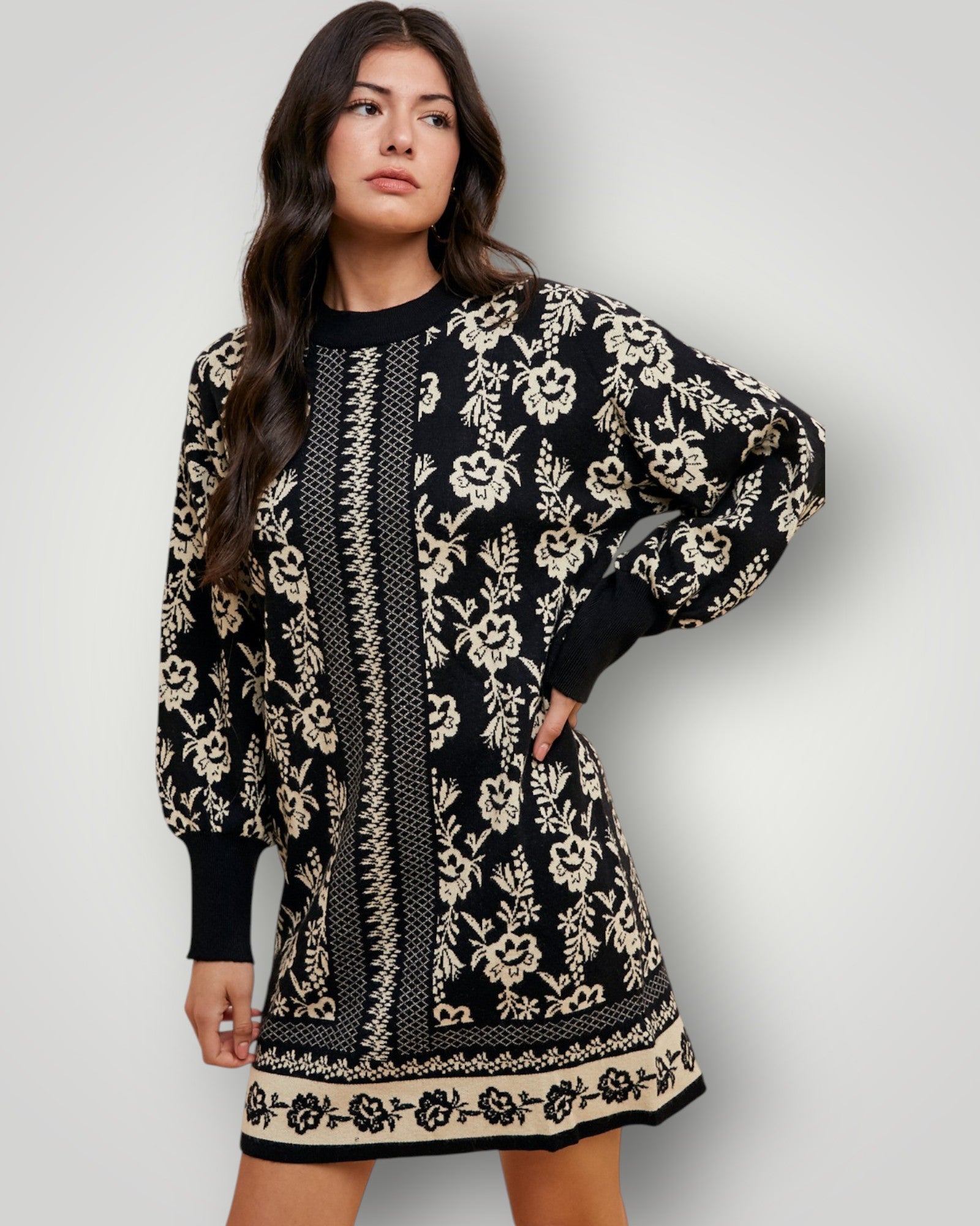 Woman wearing a black and white floral patterned dress against a plain background