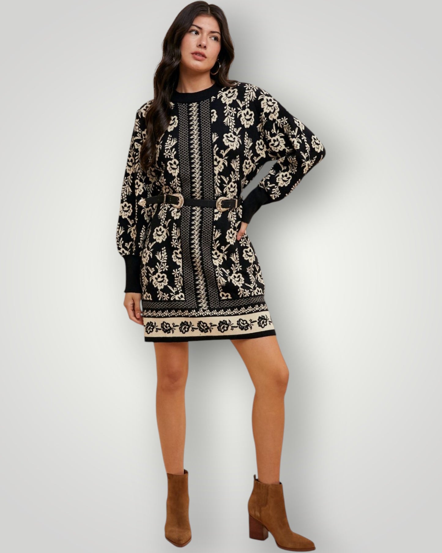 Woman wearing a black and white patterned dress with brown boots on a white background