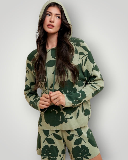 Woman wearing a green floral hoodie and pants against a white background