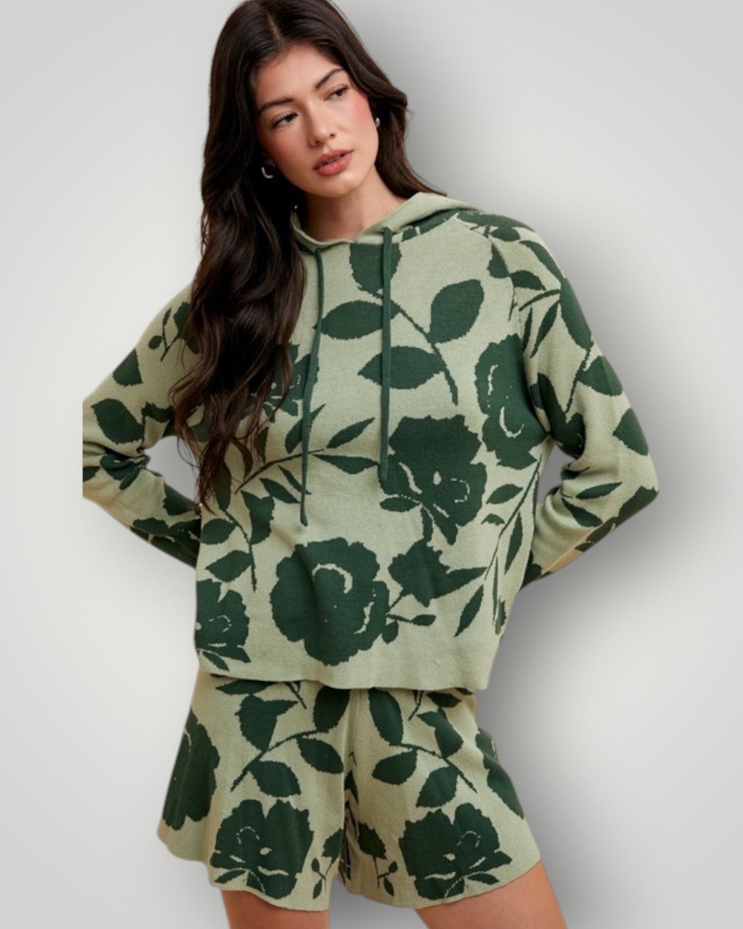 Woman wearing a green floral hoodie and shorts set on a white background
