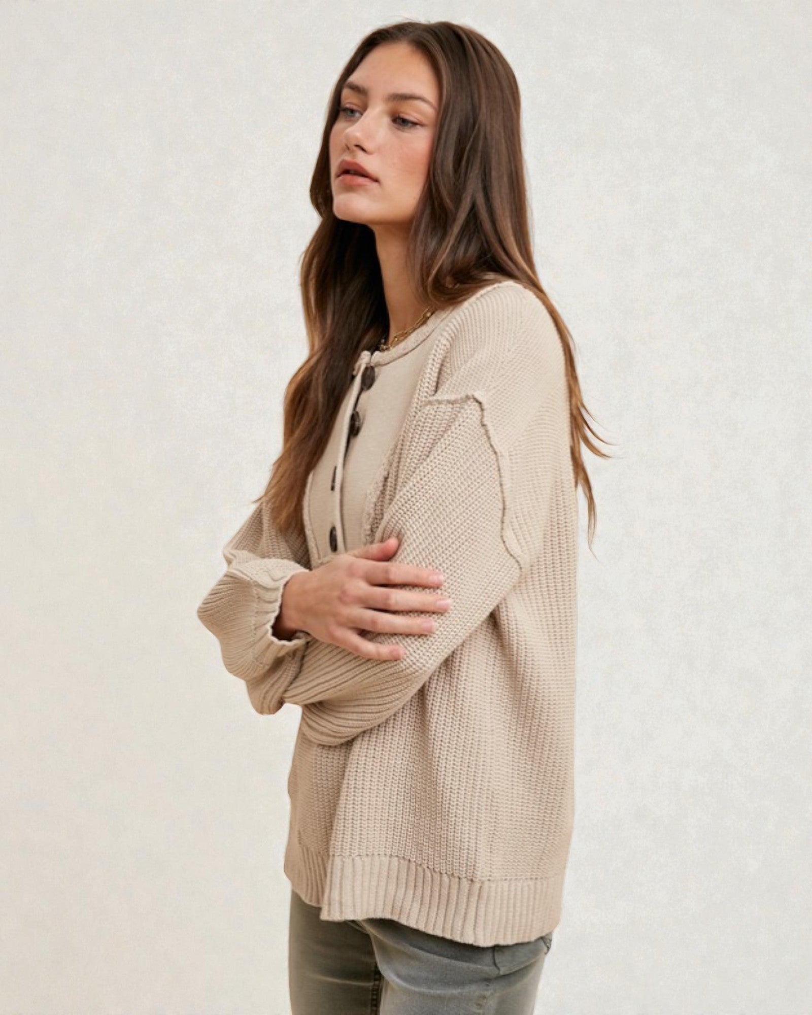 Woman wearing a beige ribbed sweater on a white background