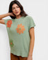 Woman wearing a green knitted top with orange floral patterns on a white background