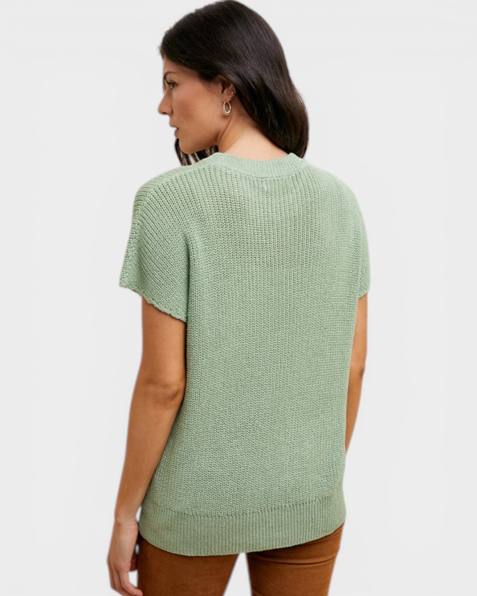 Woman wearing a green knitted sweater on a white background
