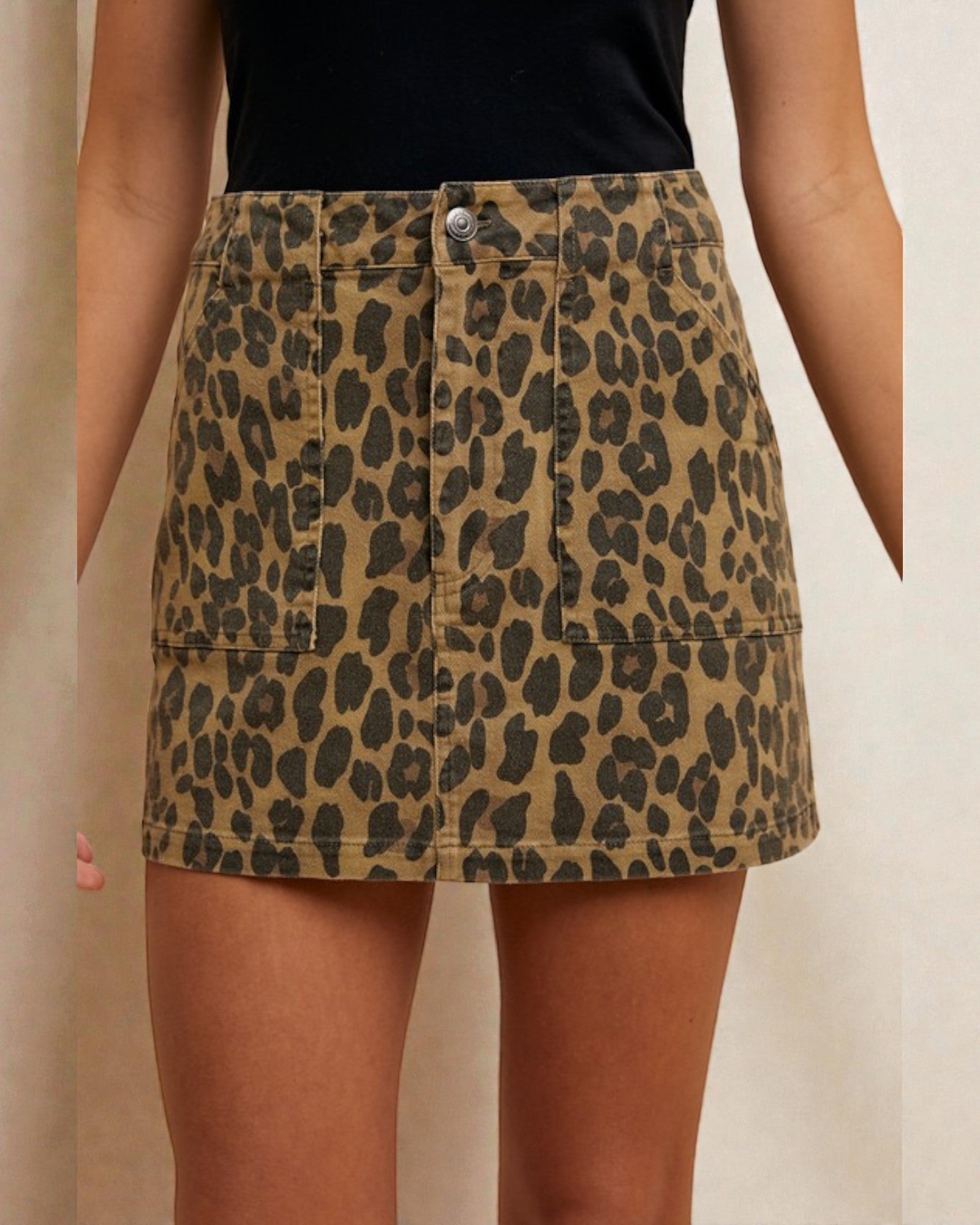 Leopard print skirt worn by a person on a beige background