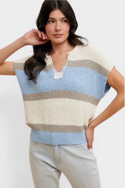 Woman wearing a striped sleeveless sweater against a white background