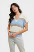 Woman wearing a colorful striped sweater and light jeans on a plain background