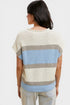 Woman wearing a striped sweater with a neutral and blue color scheme on a white background