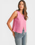 Woman wearing a pink sleeveless top and blue jeans on a white background