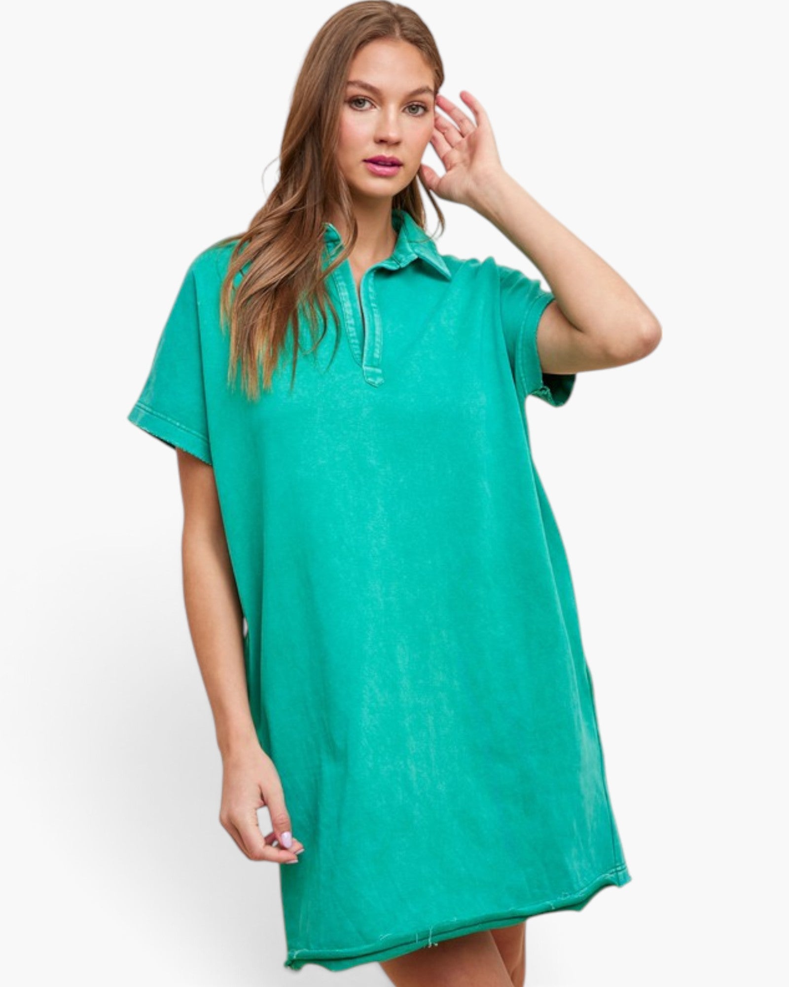 A woman modeling a short-sleeve polo shirt dress in a washed teal green color, set against a plain white studio background.