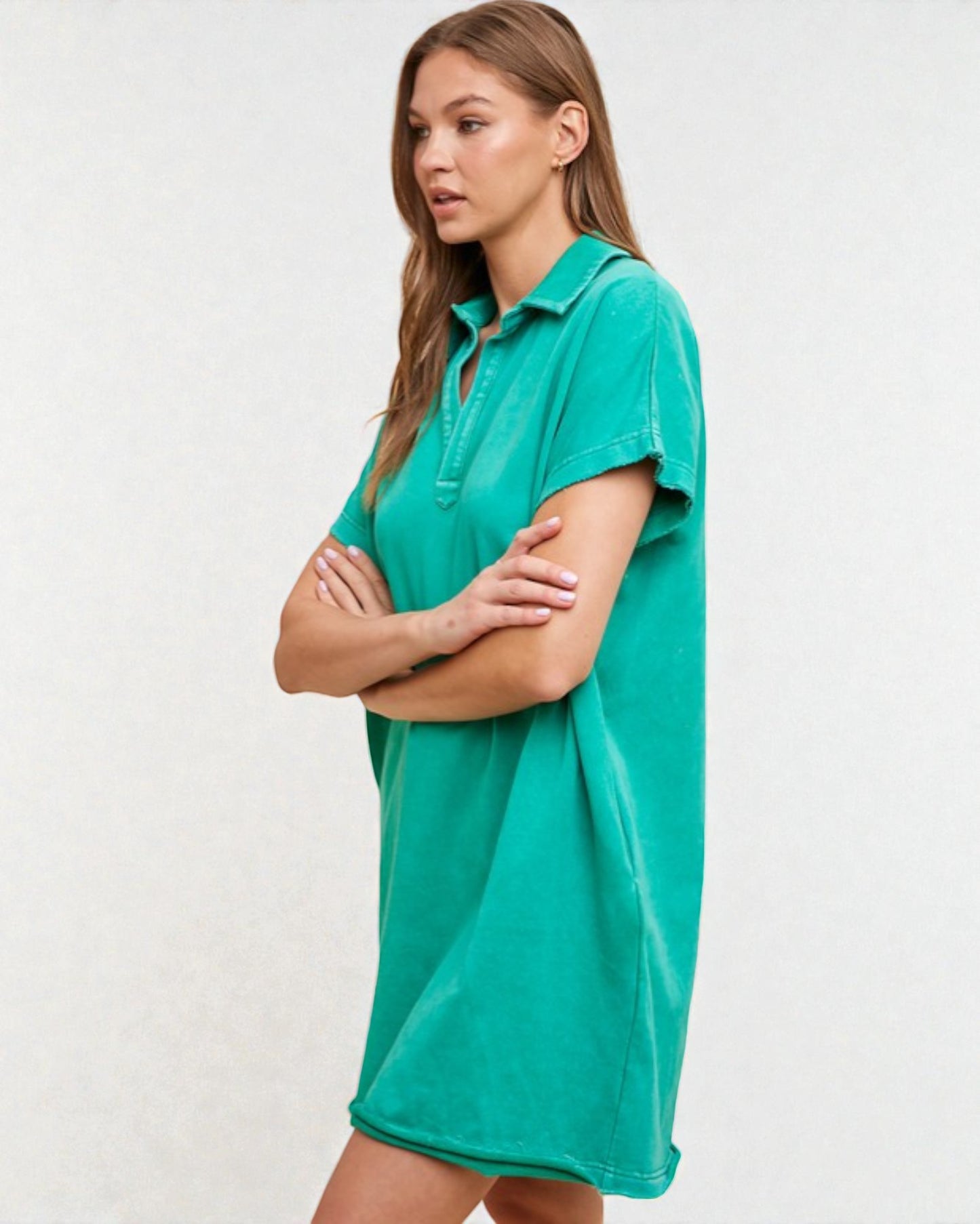 Woman wearing a teal polo shirt dress against a white background
