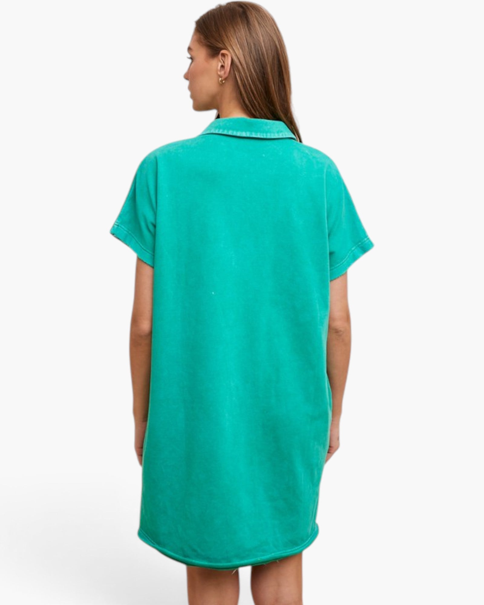 A woman viewed from the back wearing a short-sleeve collared tunic dress in a bright turquoise green color, set against a plain white studio background.