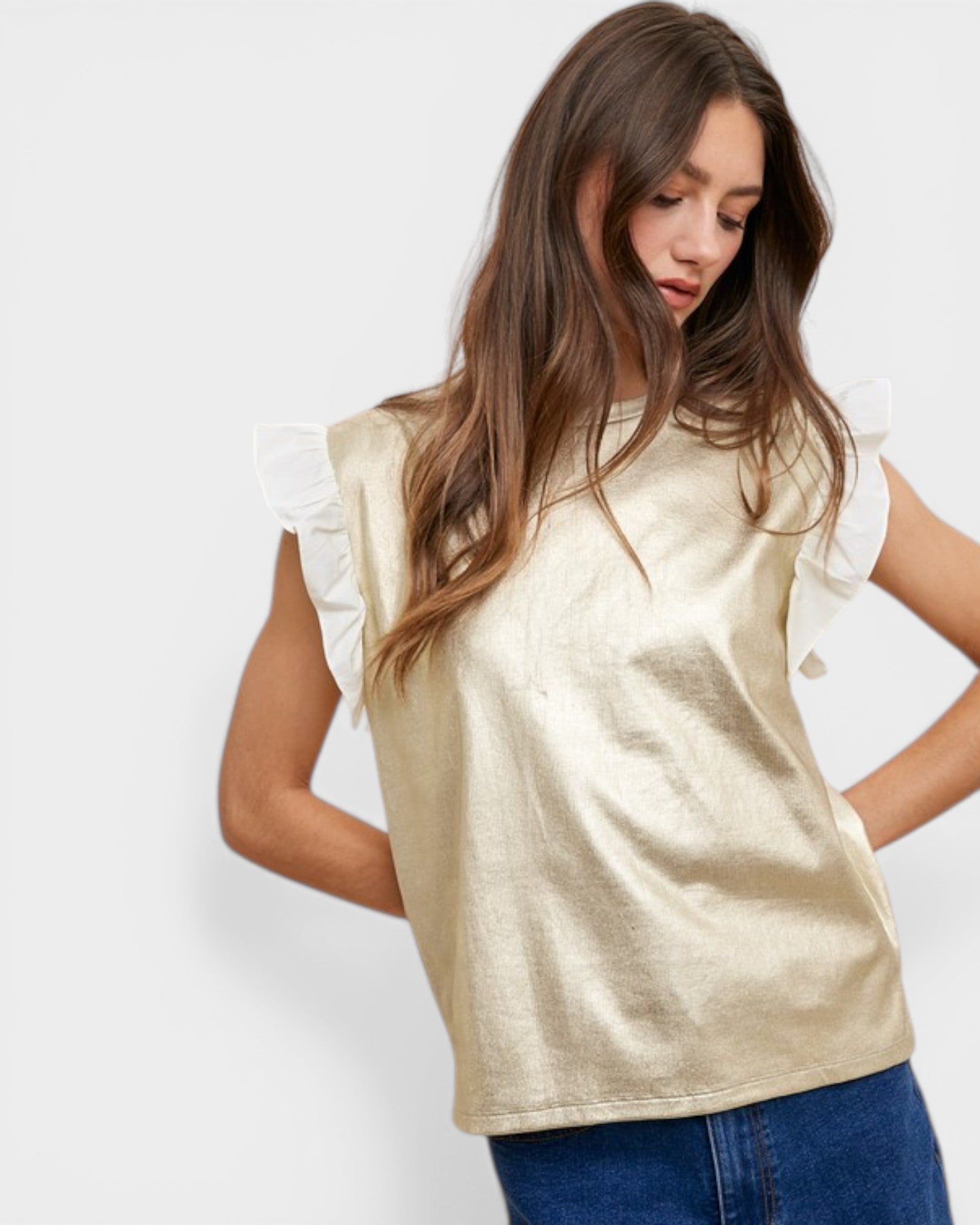 Woman wearing a gold top with ruffled sleeves on a white background