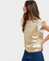 Woman wearing a gold top with ruffled sleeves on a plain background