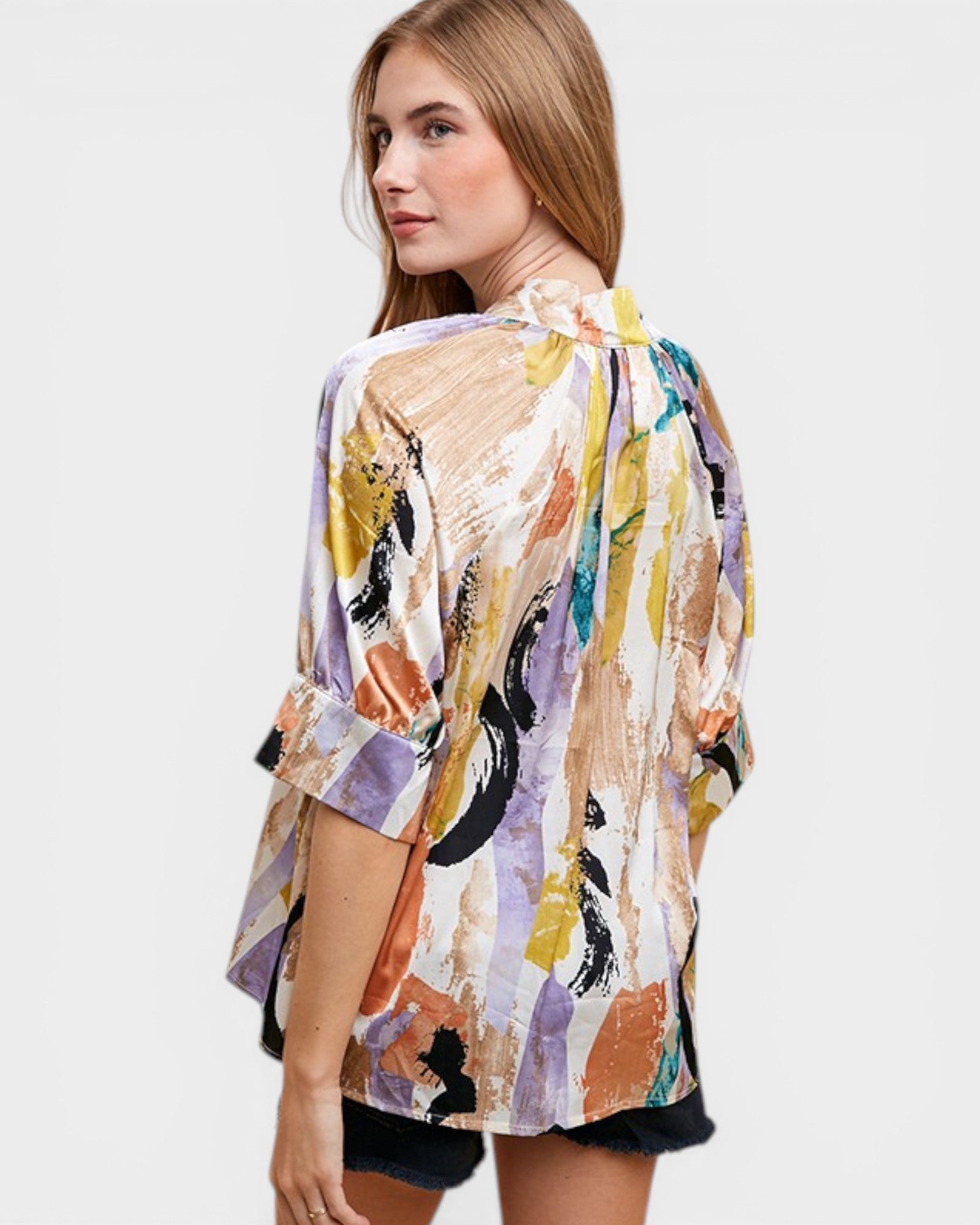 Woman wearing a colorful abstract patterned shirt on a white background