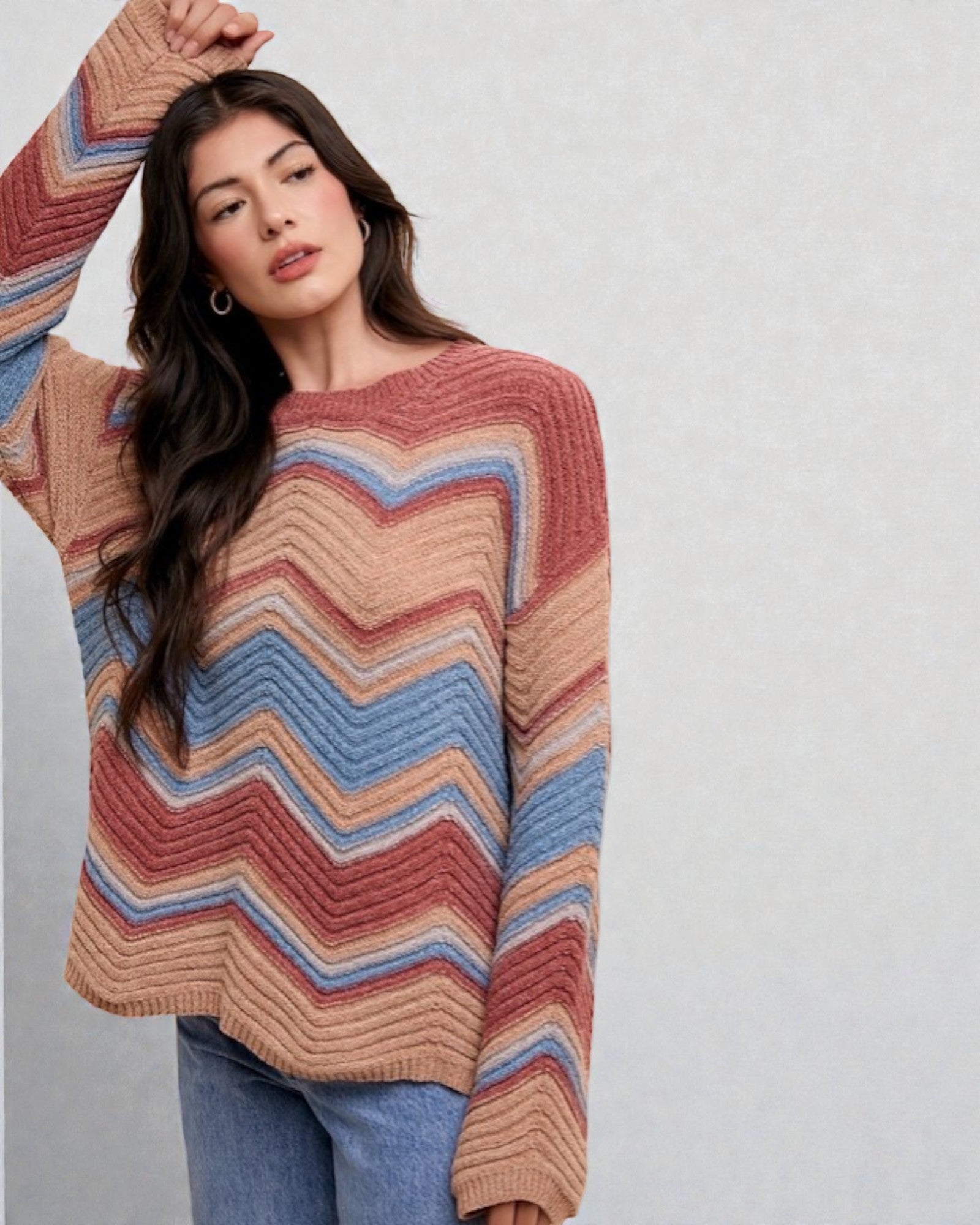 Woman wearing a colorful striped sweater against a plain background