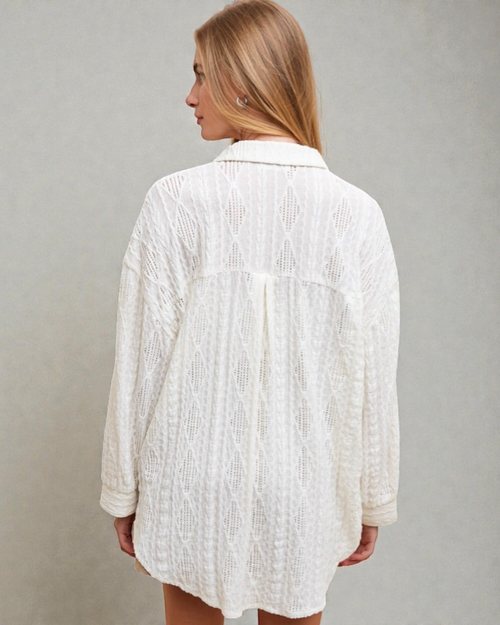Woman wearing a white textured shirt against a plain background