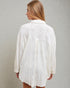 Woman wearing a white textured shirt against a plain background