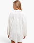 A woman shown from the back wearing a white textured, open-knit long-sleeve shirt or tunic against a plain white studio background.