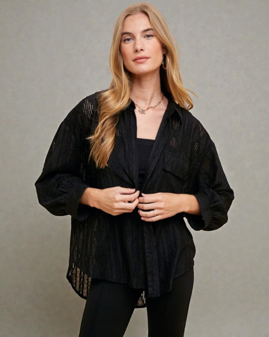 Woman wearing a black jacket against a gray background