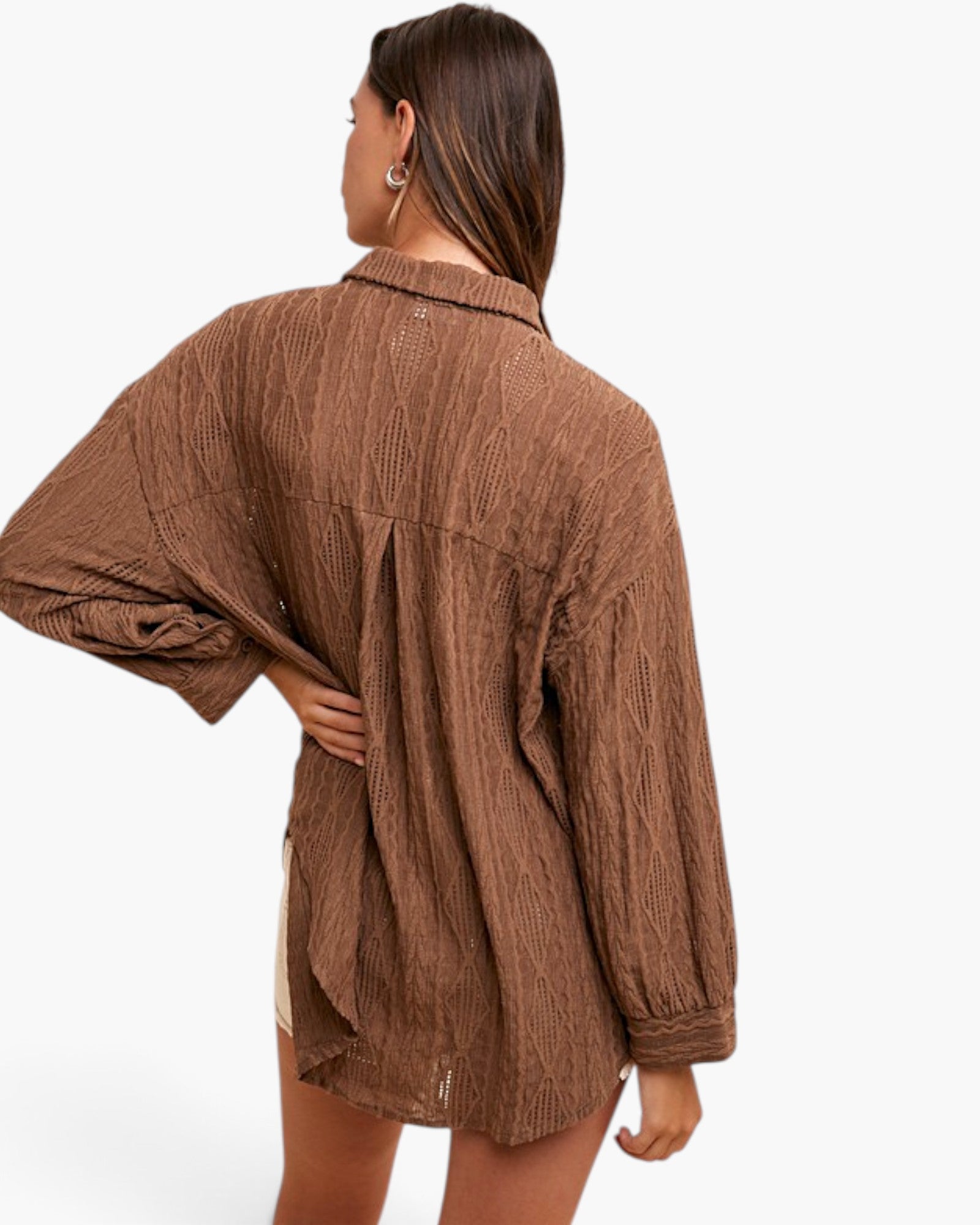 A woman shown from the back wearing an oversized brown textured button-up shirt with voluminous sleeves, photographed against a clean white studio background.