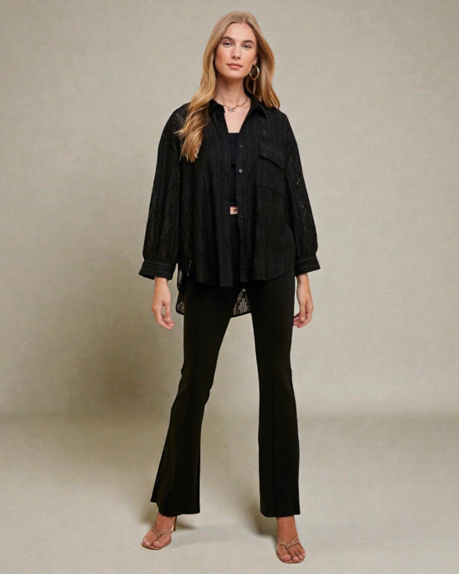 Woman wearing a black outfit against a neutral background