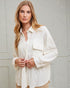 Woman wearing a white textured shirt against a light gray background