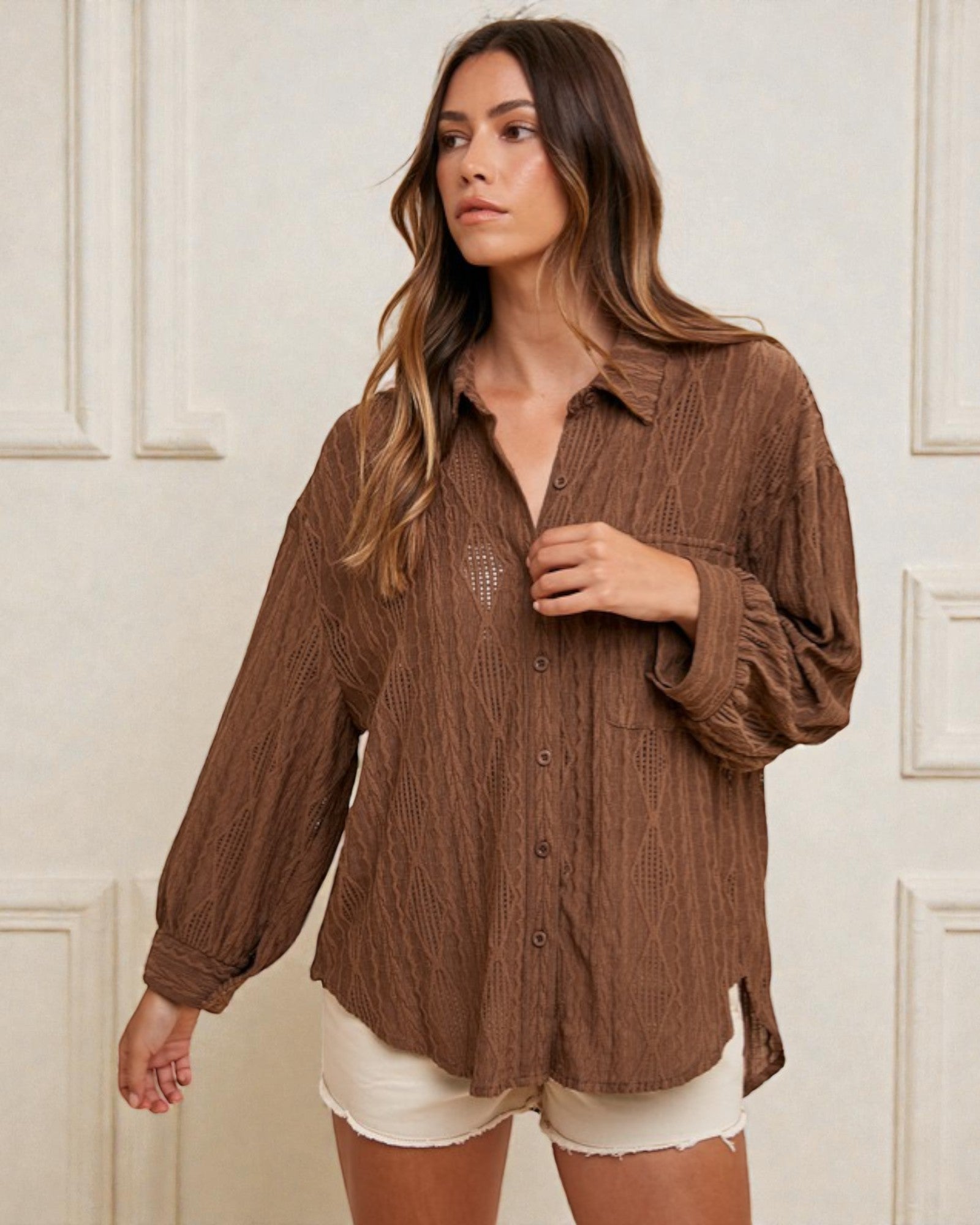 Woman wearing a brown textured shirt with a white background