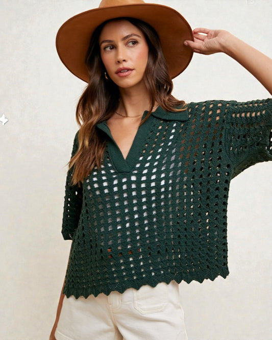 Woman wearing a green crochet top and brown hat against a white background