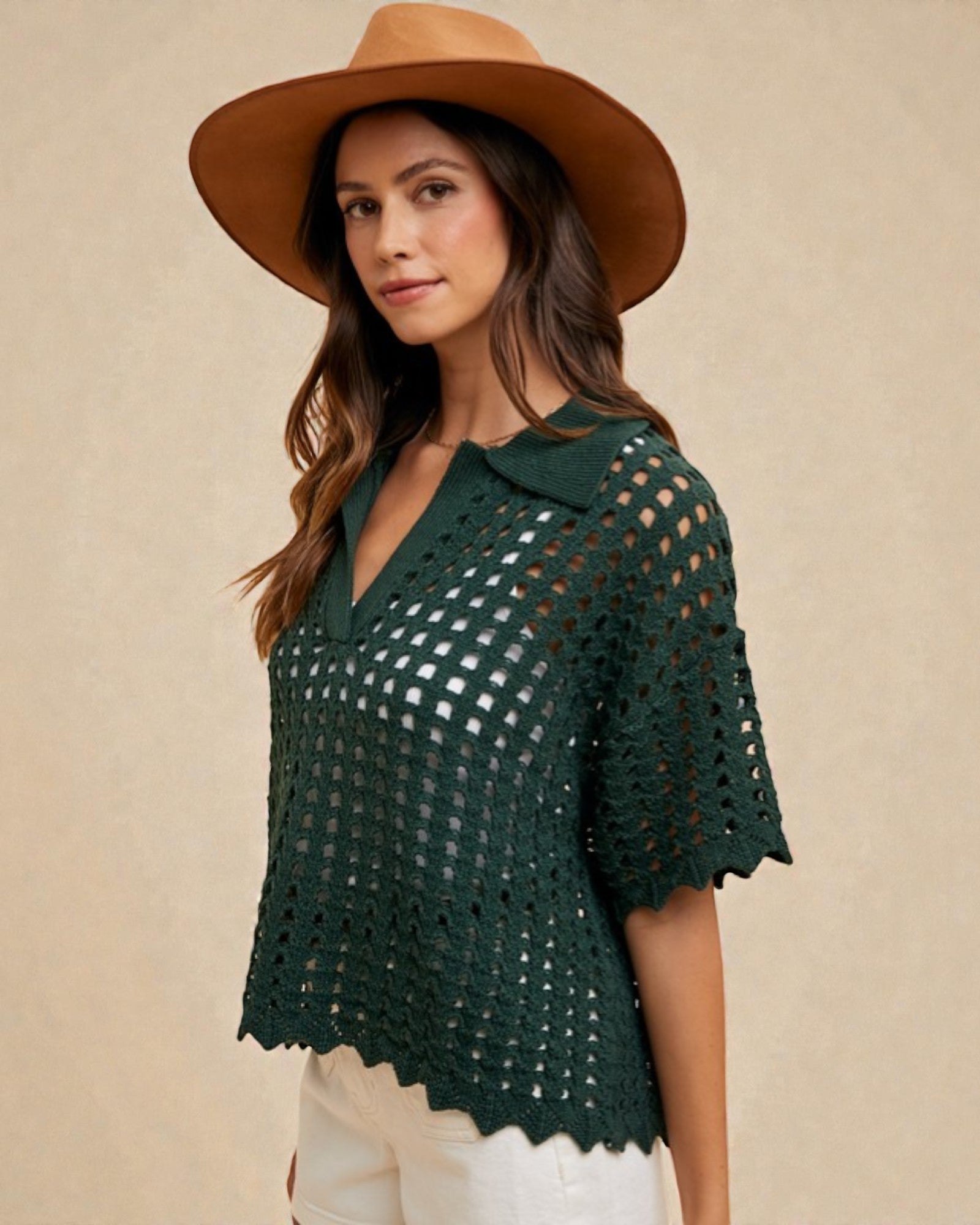 Woman wearing a green crochet top and brown hat against a beige background
