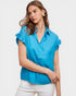 Woman wearing a blue blouse with ruffled sleeves on a white background