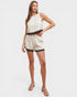 Woman wearing a white outfit with black trim on a white background
