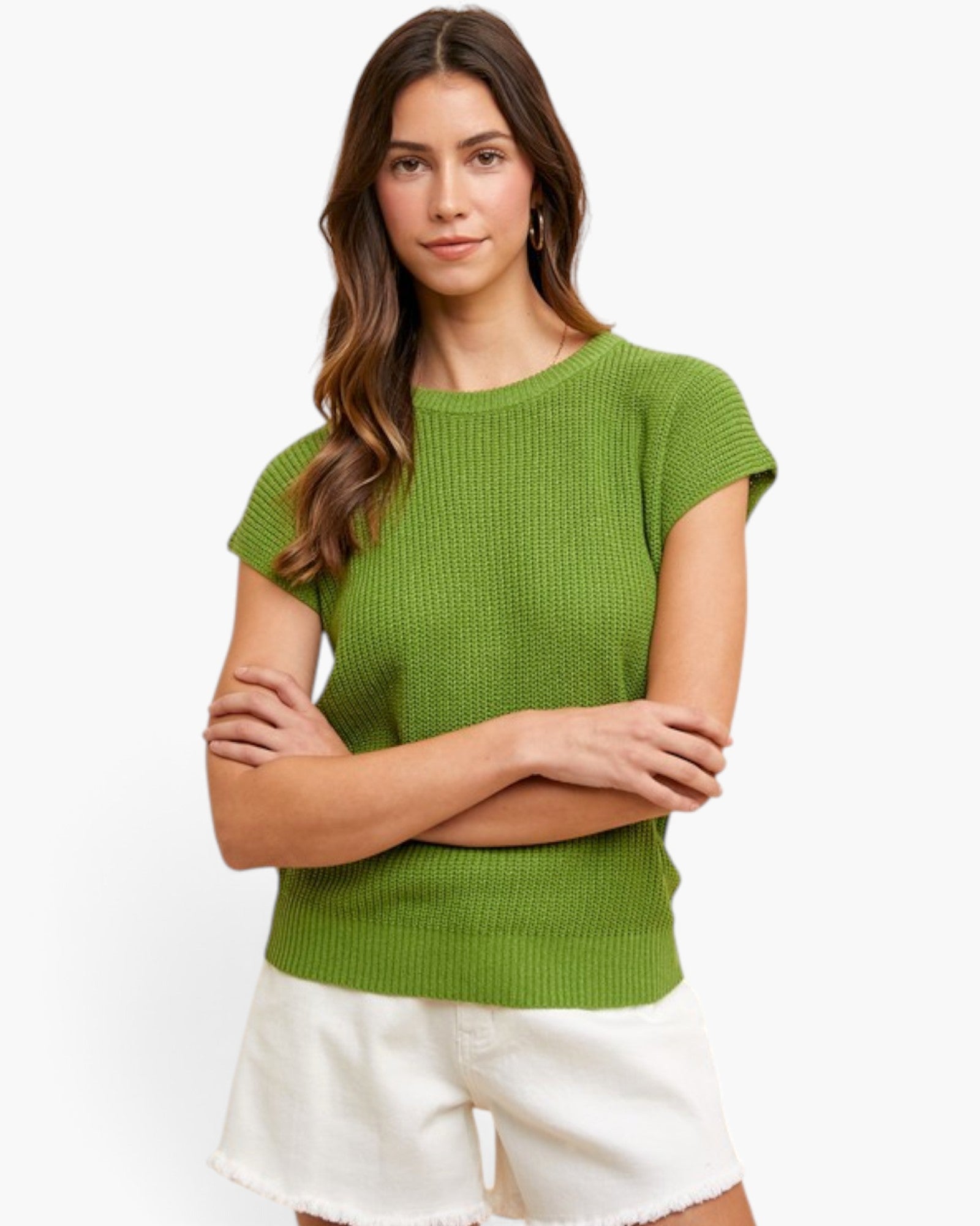 A woman modeling a bright green short-sleeve ribbed knit top with white shorts against a plain white studio background.