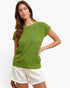 A woman modeling a bright lime green short-sleeve ribbed knit sweater with white shorts against a plain white studio background.