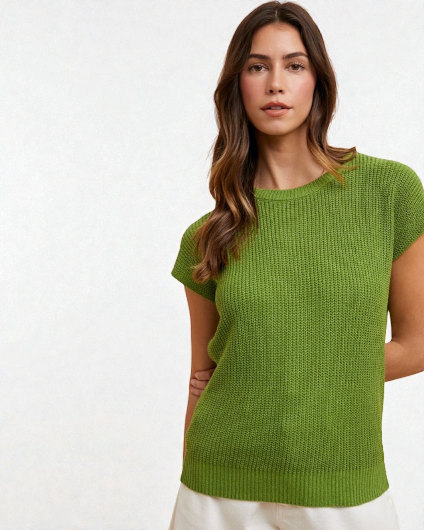 Woman wearing a green knitted top against a white background